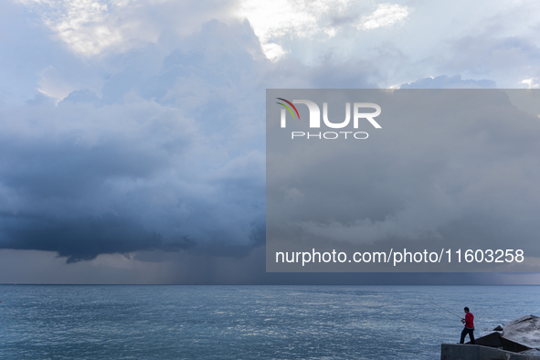 Fishermen and some passers-by are surprised by the unstable autumn weather on the Barcelona coast, in Barcelona, Spain, on September 23, 202...