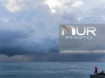 Fishermen and some passers-by are surprised by the unstable autumn weather on the Barcelona coast, in Barcelona, Spain, on September 23, 202...