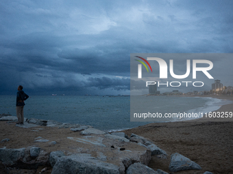 Fishermen and some passers-by are surprised by the unstable autumn weather on the Barcelona coast, in Barcelona, Spain, on September 23, 202...