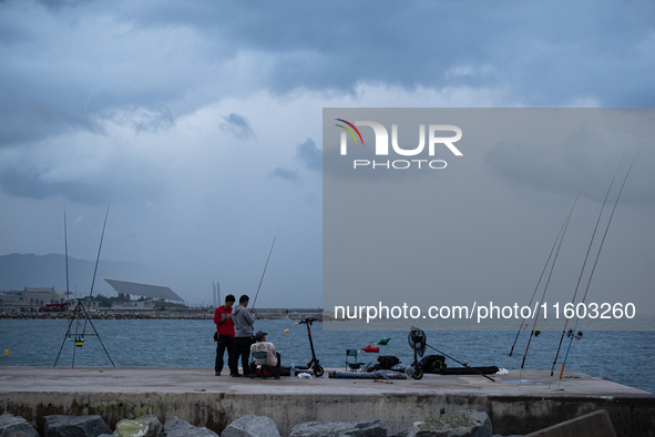 Fishermen and some passers-by are surprised by the unstable autumn weather on the Barcelona coast, in Barcelona, Spain, on September 23, 202...