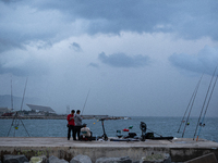 Fishermen and some passers-by are surprised by the unstable autumn weather on the Barcelona coast, in Barcelona, Spain, on September 23, 202...