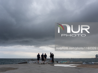 Fishermen and some passers-by are surprised by the unstable autumn weather on the Barcelona coast, in Barcelona, Spain, on September 23, 202...