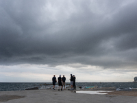 Fishermen and some passers-by are surprised by the unstable autumn weather on the Barcelona coast, in Barcelona, Spain, on September 23, 202...