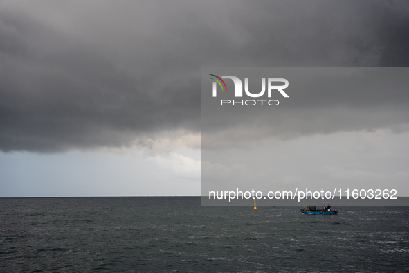 Fishermen and some passers-by are surprised by the unstable autumn weather on the Barcelona coast, in Barcelona, Spain, on September 23, 202...