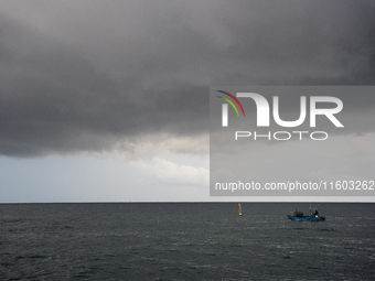 Fishermen and some passers-by are surprised by the unstable autumn weather on the Barcelona coast, in Barcelona, Spain, on September 23, 202...