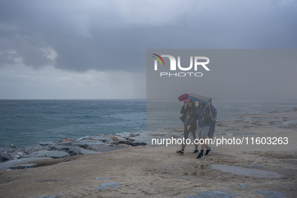 Fishermen and some passers-by are surprised by the unstable autumn weather on the Barcelona coast, in Barcelona, Spain, on September 23, 202...