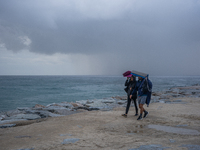 Fishermen and some passers-by are surprised by the unstable autumn weather on the Barcelona coast, in Barcelona, Spain, on September 23, 202...