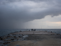 Fishermen and some passers-by are surprised by the unstable autumn weather on the Barcelona coast, in Barcelona, Spain, on September 23, 202...