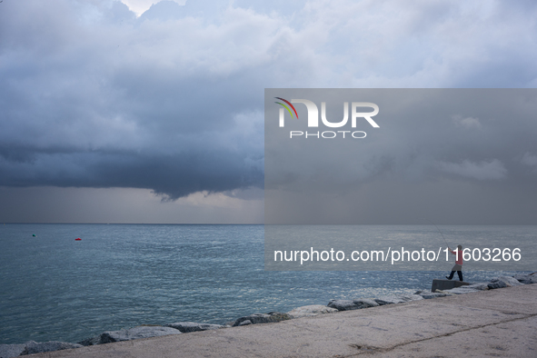 Fishermen and some passers-by are surprised by the unstable autumn weather on the Barcelona coast, in Barcelona, Spain, on September 23, 202...