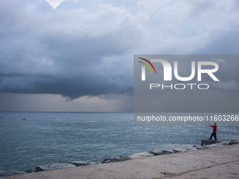 Fishermen and some passers-by are surprised by the unstable autumn weather on the Barcelona coast, in Barcelona, Spain, on September 23, 202...