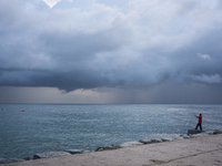 Fishermen and some passers-by are surprised by the unstable autumn weather on the Barcelona coast, in Barcelona, Spain, on September 23, 202...