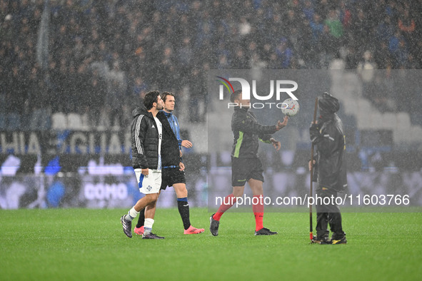 Referee Paride Tremolada tests the football field with captain Rafael Toloi (Atalanta) and Patrick Cutrone (Como) before the Italian Serie A...