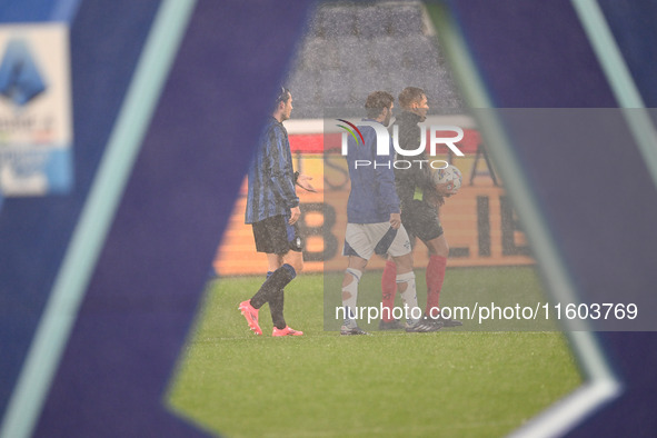 Referee Paride Tremolada tests the football field with captain Rafael Toloi (Atalanta) and Patrick Cutrone (Como) before the Italian Serie A...