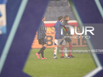 Referee Paride Tremolada tests the football field with captain Rafael Toloi (Atalanta) and Patrick Cutrone (Como) before the Italian Serie A...