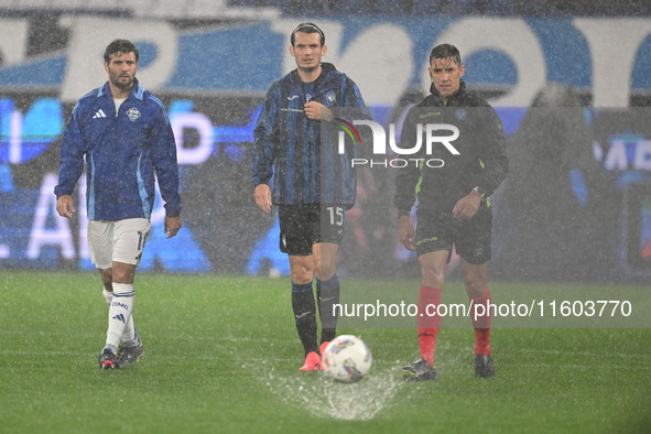 Referee Paride Tremolada tests the football field with captain Rafael Toloi (Atalanta) and Patrick Cutrone (Como) before the Italian Serie A...