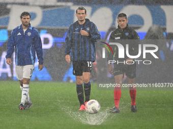 Referee Paride Tremolada tests the football field with captain Rafael Toloi (Atalanta) and Patrick Cutrone (Como) before the Italian Serie A...