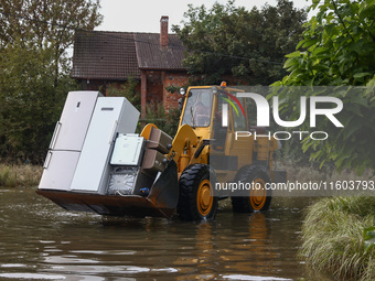 A digger is cleaning residential area which was damaged by water after Nysa Klodzka river flooded town of Lewin Brzeski in southwestern Pola...