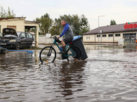 A man rides a bicycle in the water after Nysa Klodzka river flooded town of Lewin Brzeski in southwestern Poland. September 23rd, 2024. Stor...