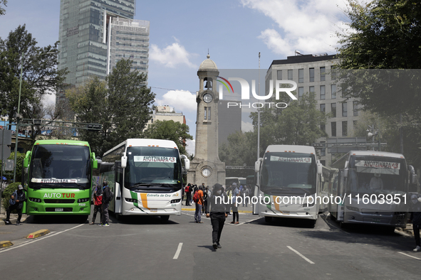 A busload of comrades of the 43 missing students from Ayotzinapa stands outside the Ministry of the Interior in Mexico City, Mexico, on Sept...