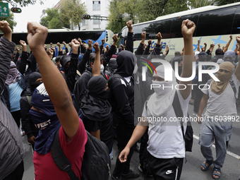 Colleagues of the 43 missing students from Ayotzinapa protest with fists raised outside the Ministry of the Interior in Mexico City, Mexico,...