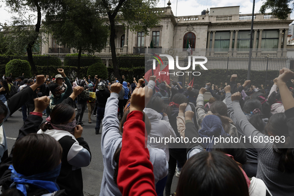 Colleagues of the 43 missing students from Ayotzinapa protest with fists raised outside the Ministry of the Interior in Mexico City, Mexico,...