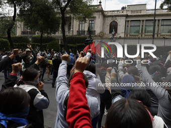 Colleagues of the 43 missing students from Ayotzinapa protest with fists raised outside the Ministry of the Interior in Mexico City, Mexico,...