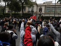 Colleagues of the 43 missing students from Ayotzinapa protest with fists raised outside the Ministry of the Interior in Mexico City, Mexico,...