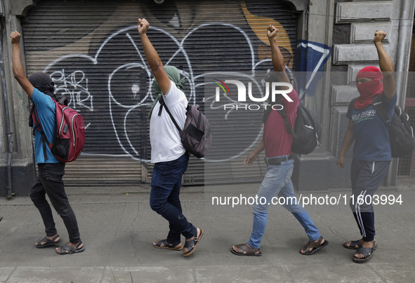 Colleagues of the 43 missing students from Ayotzinapa protest with fists raised outside the Ministry of the Interior in Mexico City, Mexico,...