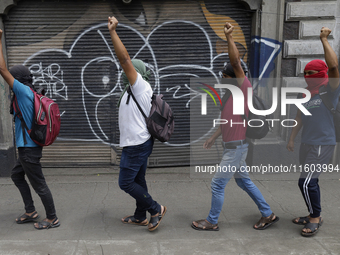 Colleagues of the 43 missing students from Ayotzinapa protest with fists raised outside the Ministry of the Interior in Mexico City, Mexico,...