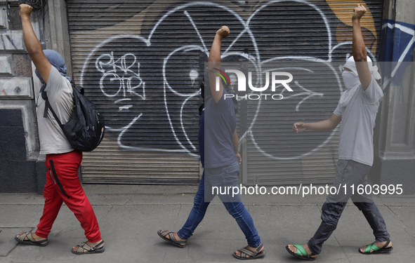 Colleagues of the 43 missing students from Ayotzinapa protest with fists raised outside the Ministry of the Interior in Mexico City, Mexico,...