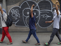 Colleagues of the 43 missing students from Ayotzinapa protest with fists raised outside the Ministry of the Interior in Mexico City, Mexico,...