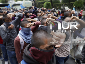 Colleagues of the 43 missing students from Ayotzinapa protest with fists raised outside the Ministry of the Interior in Mexico City, Mexico,...