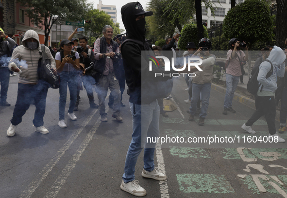 Colleagues of the 43 missing students from Ayotzinapa fire rockets on Monday, September 23, 2024, outside the Ministry of the Interior in Me...