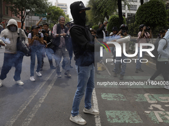 Colleagues of the 43 missing students from Ayotzinapa fire rockets on Monday, September 23, 2024, outside the Ministry of the Interior in Me...