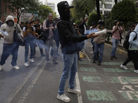 Colleagues of the 43 missing students from Ayotzinapa fire rockets on Monday, September 23, 2024, outside the Ministry of the Interior in Me...