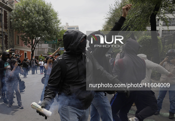 Colleagues of the 43 missing students from Ayotzinapa fire rockets on Monday, September 23, 2024, outside the Ministry of the Interior in Me...