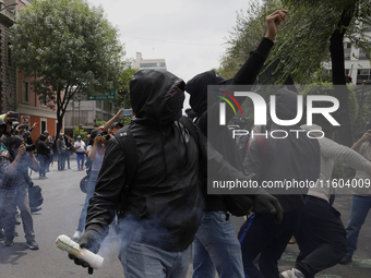 Colleagues of the 43 missing students from Ayotzinapa fire rockets on Monday, September 23, 2024, outside the Ministry of the Interior in Me...