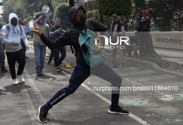 Colleagues of the 43 missing students from Ayotzinapa fire rockets on Monday, September 23, 2024, outside the Ministry of the Interior in Me...