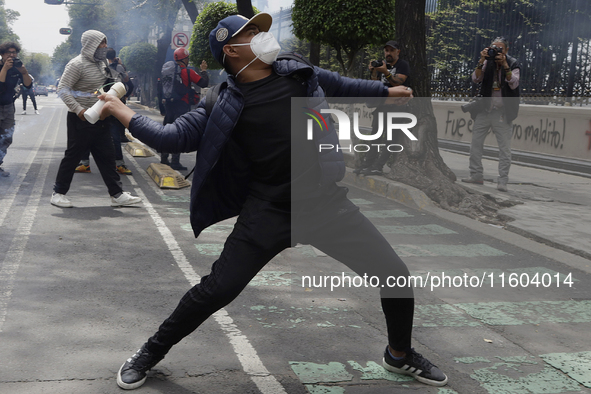 Colleagues of the 43 missing students from Ayotzinapa fire rockets on Monday, September 23, 2024, outside the Ministry of the Interior in Me...