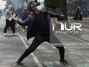 Colleagues of the 43 missing students from Ayotzinapa fire rockets on Monday, September 23, 2024, outside the Ministry of the Interior in Me...