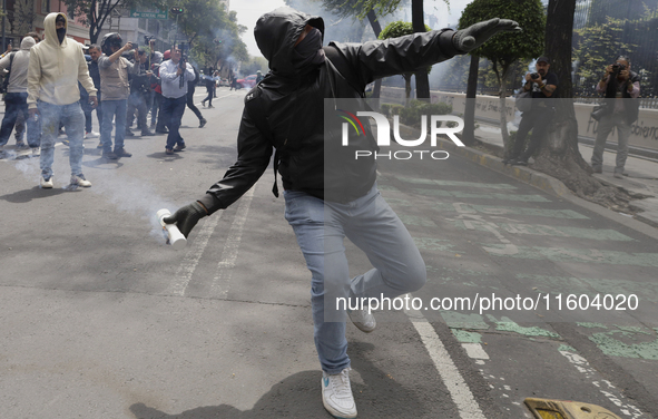 Colleagues of the 43 missing students from Ayotzinapa fire rockets on Monday, September 23, 2024, outside the Ministry of the Interior in Me...