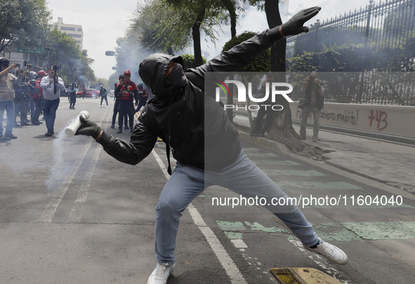 Colleagues of the 43 missing students from Ayotzinapa fire rockets on Monday, September 23, 2024, outside the Ministry of the Interior in Me...