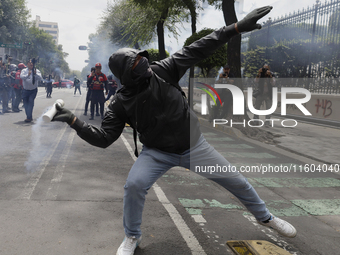 Colleagues of the 43 missing students from Ayotzinapa fire rockets on Monday, September 23, 2024, outside the Ministry of the Interior in Me...