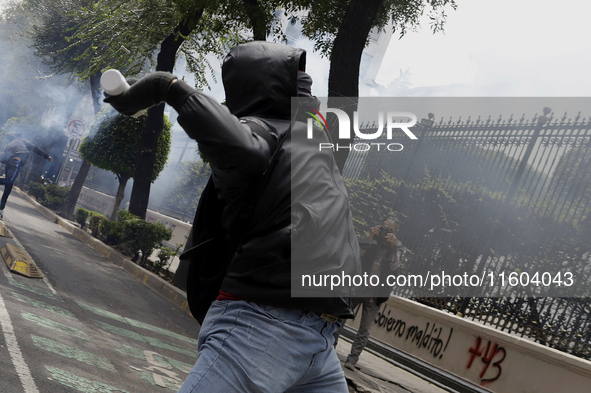 Colleagues of the 43 missing students from Ayotzinapa fire rockets on Monday, September 23, 2024, outside the Ministry of the Interior in Me...