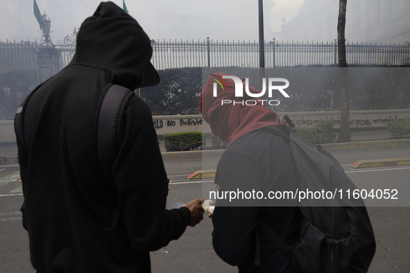 Colleagues of the 43 missing students from Ayotzinapa fire rockets on Monday, September 23, 2024, outside the Ministry of the Interior in Me...