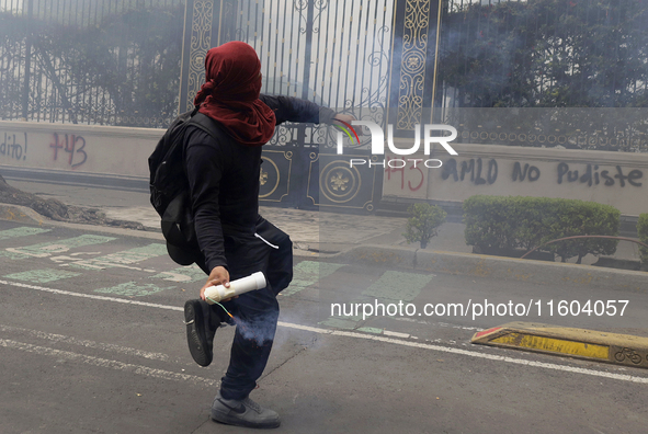 Colleagues of the 43 missing students from Ayotzinapa fire rockets on Monday, September 23, 2024, outside the Ministry of the Interior in Me...