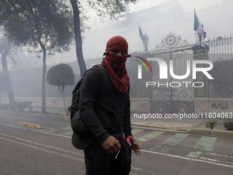 Colleagues of the 43 missing students from Ayotzinapa fire rockets on Monday, September 23, 2024, outside the Ministry of the Interior in Me...