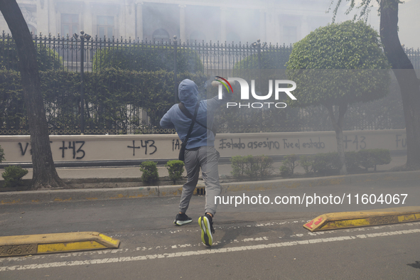 Colleagues of the 43 missing students from Ayotzinapa fire rockets on Monday, September 23, 2024, outside the Ministry of the Interior in Me...