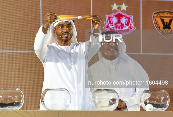 A member of the organizing committee shows the name of Dhofar of Oman during the 2024-25 Gulf Club Champions League draw ceremony in Doha, Q...