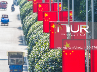 National flags fly along the Golden Buddha Avenue to celebrate the upcoming National Day in Chongqing, China, on September 24, 2024. (